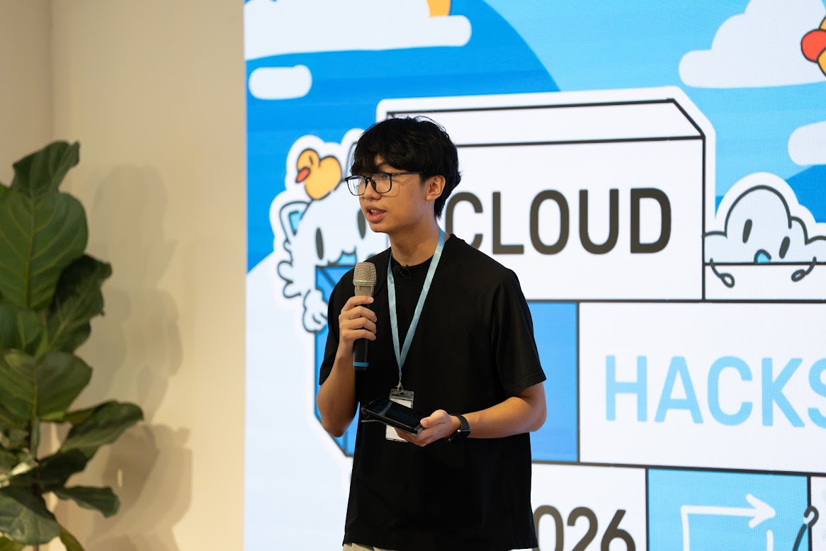 Nhat Minh speaking at an event, holding a microphone